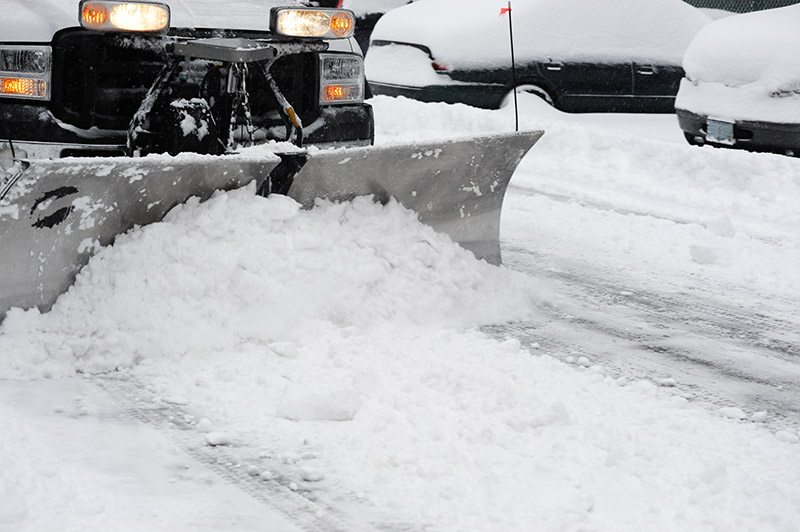 snowplow removing snow on the street after blizzard